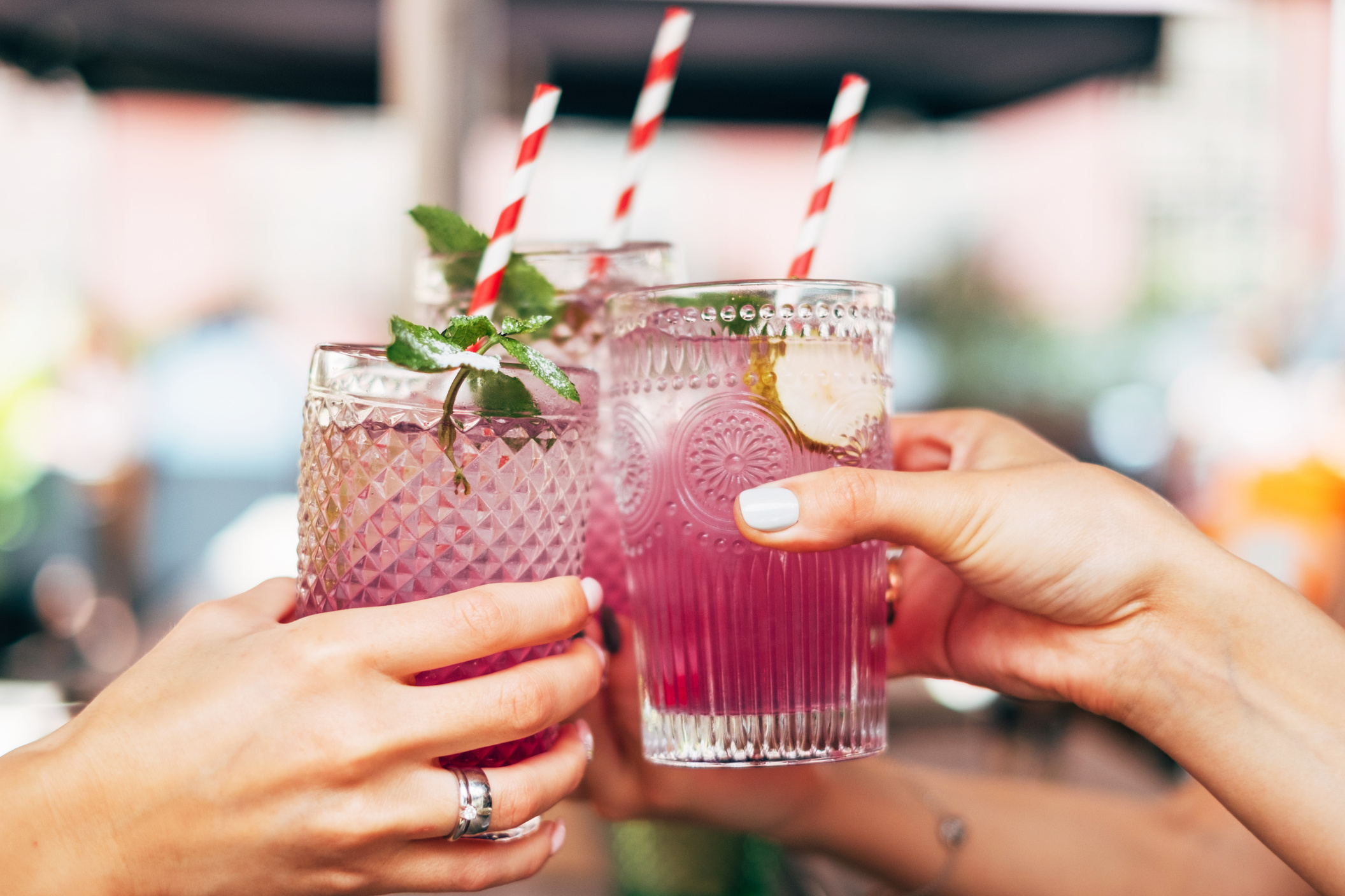 Women hands toasting with summer cocktails